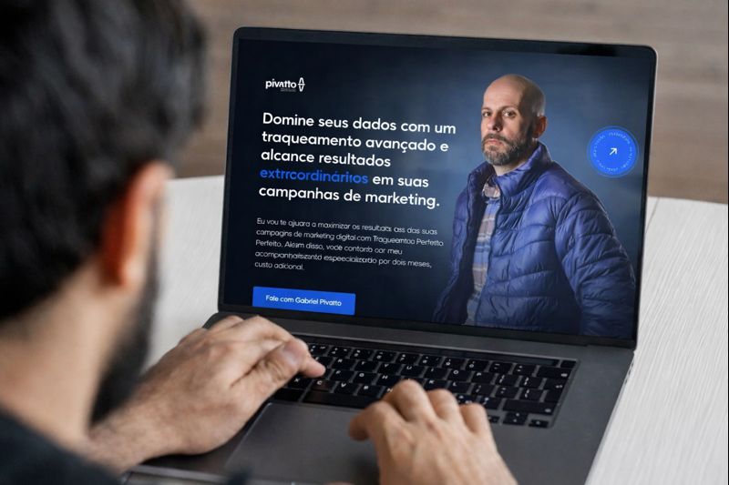 Pessoa utilizando notebook com landing page de tráfego pago exibida na tela, focada em conversão e otimização de campanhas digitais